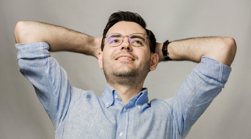 Wojciech Wawrzak, autor artykułu, siedzi uśmiechnięty z założnymi rękoma za głowę